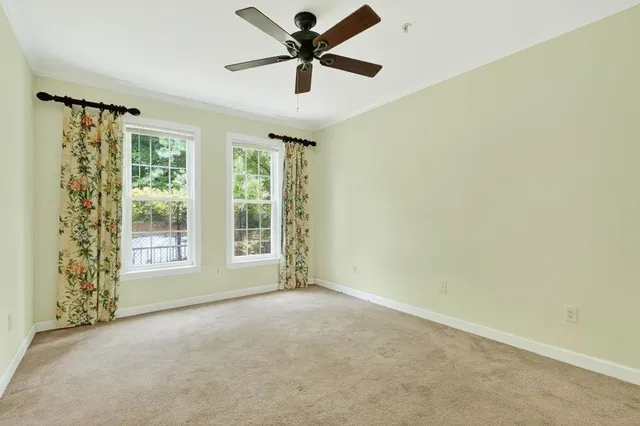 a view of a livingroom with a ceiling fan and window