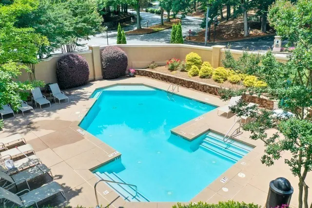 a view of a swimming pool with a patio and a yard