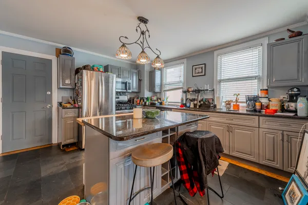 a kitchen with stainless steel appliances granite countertop a sink a stove a refrigerator and island