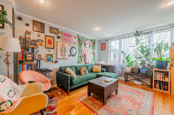 a living room with furniture a bookshelf and a window