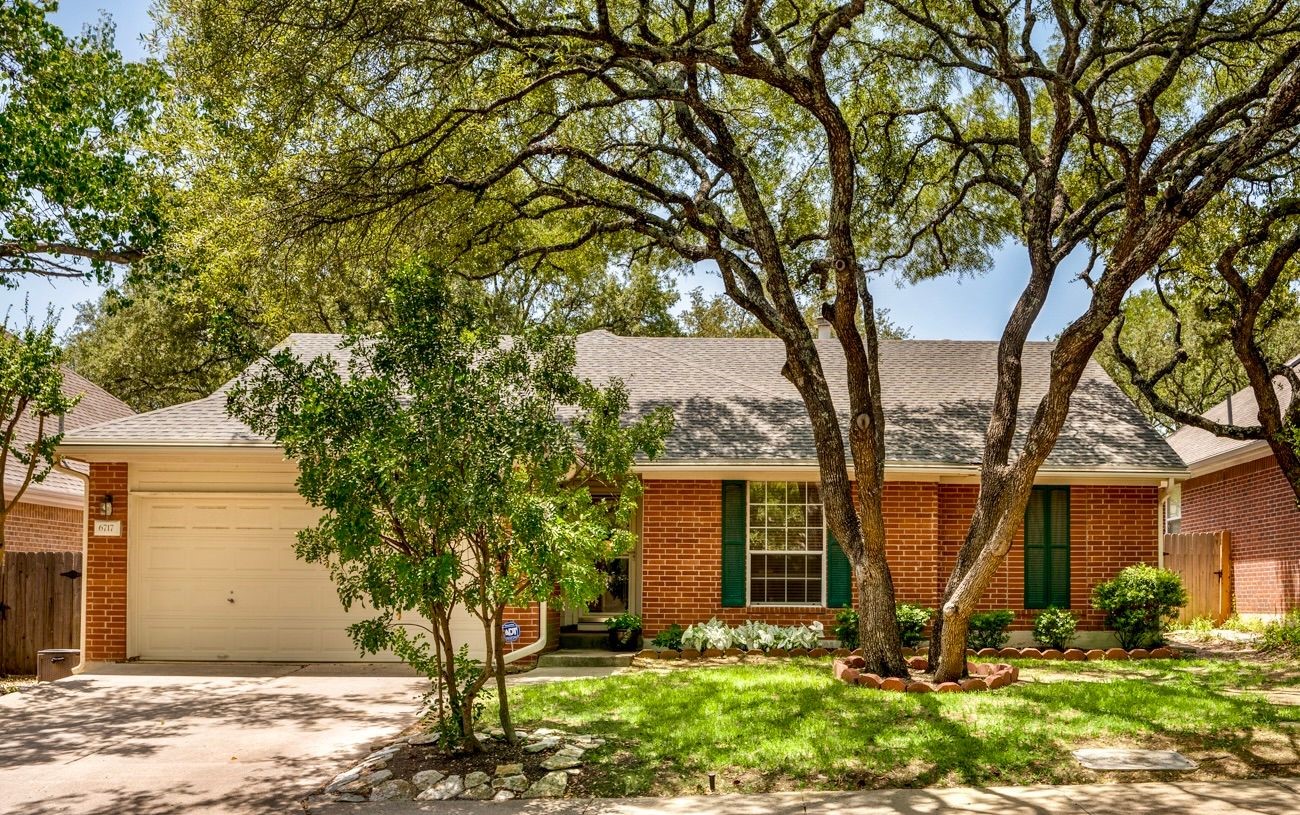 a view of a house with backyard and trees