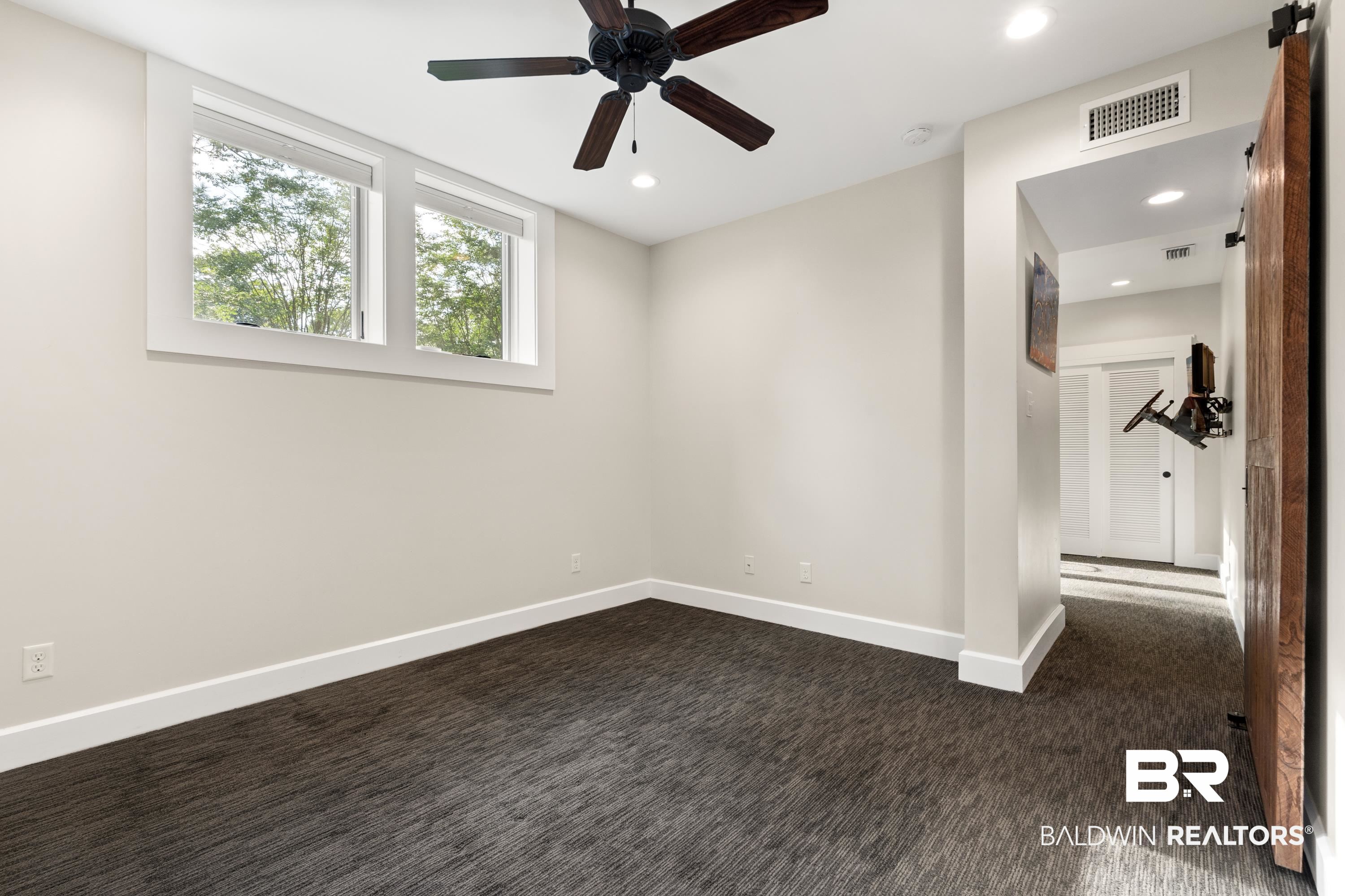 233 Suzanne Circle Mobile, AL 36608 - Photo 47 of 85 Spare room featuring dark carpet, recessed lighting, a ceiling fan, and a barn door