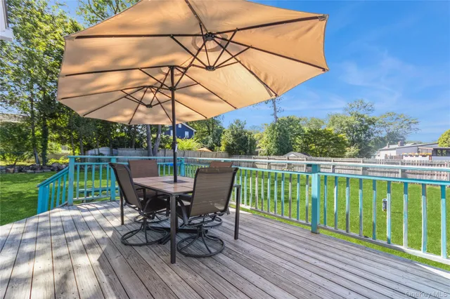 a view of a roof deck with table and chairs under an umbrella
