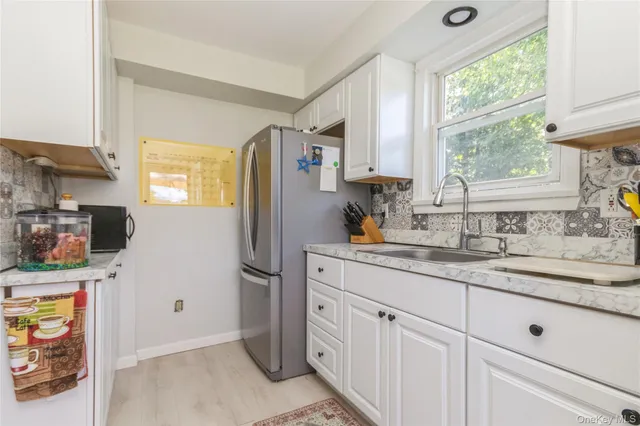 a kitchen with stainless steel appliances granite countertop a refrigerator sink and window