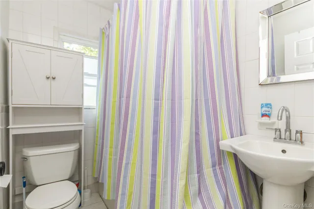a bathroom with a sink a toilet and shower curtain