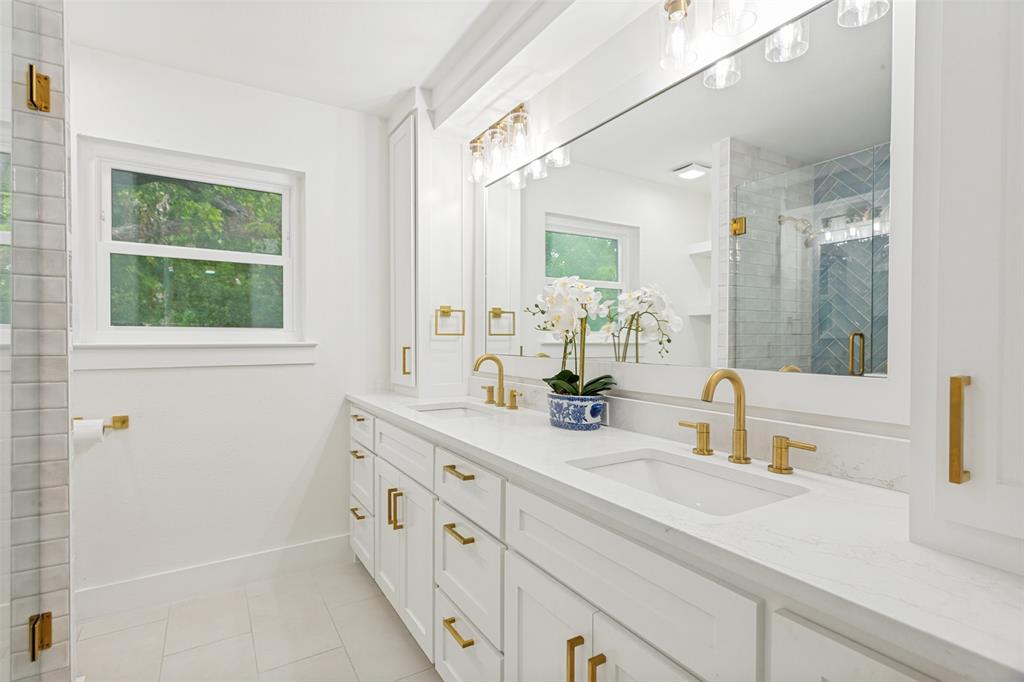 4316 Springbranch Drive Benbrook, TX 76116 - Photo 25 of 39 Dual vanity featuring white shaker cabinetry, gold-finish hardware, and a light-toned countertop