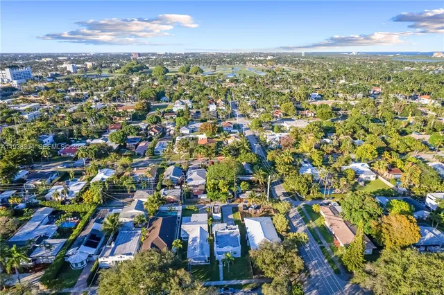 an aerial view of residential houses with outdoor space and trees