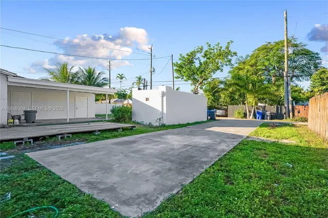 a view of a house with a backyard and a tree