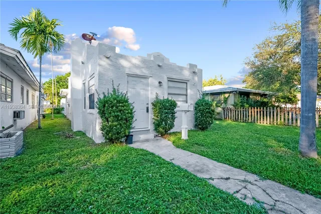 a view of a house with a yard and potted plants