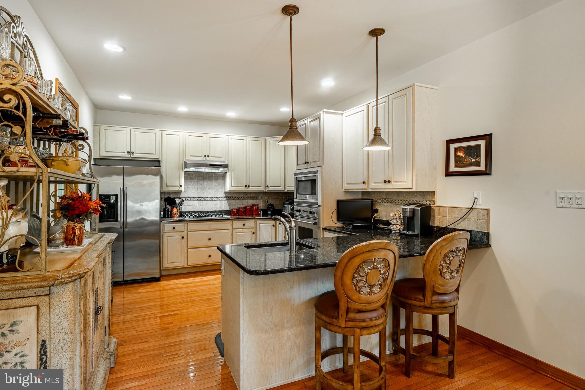 2 River Road Philadelphia, PA 19128 - Photo 16 of 46 a kitchen with stainless steel appliances granite countertop a kitchen island a stove a refrigerator a dining table and chairs with wooden floor