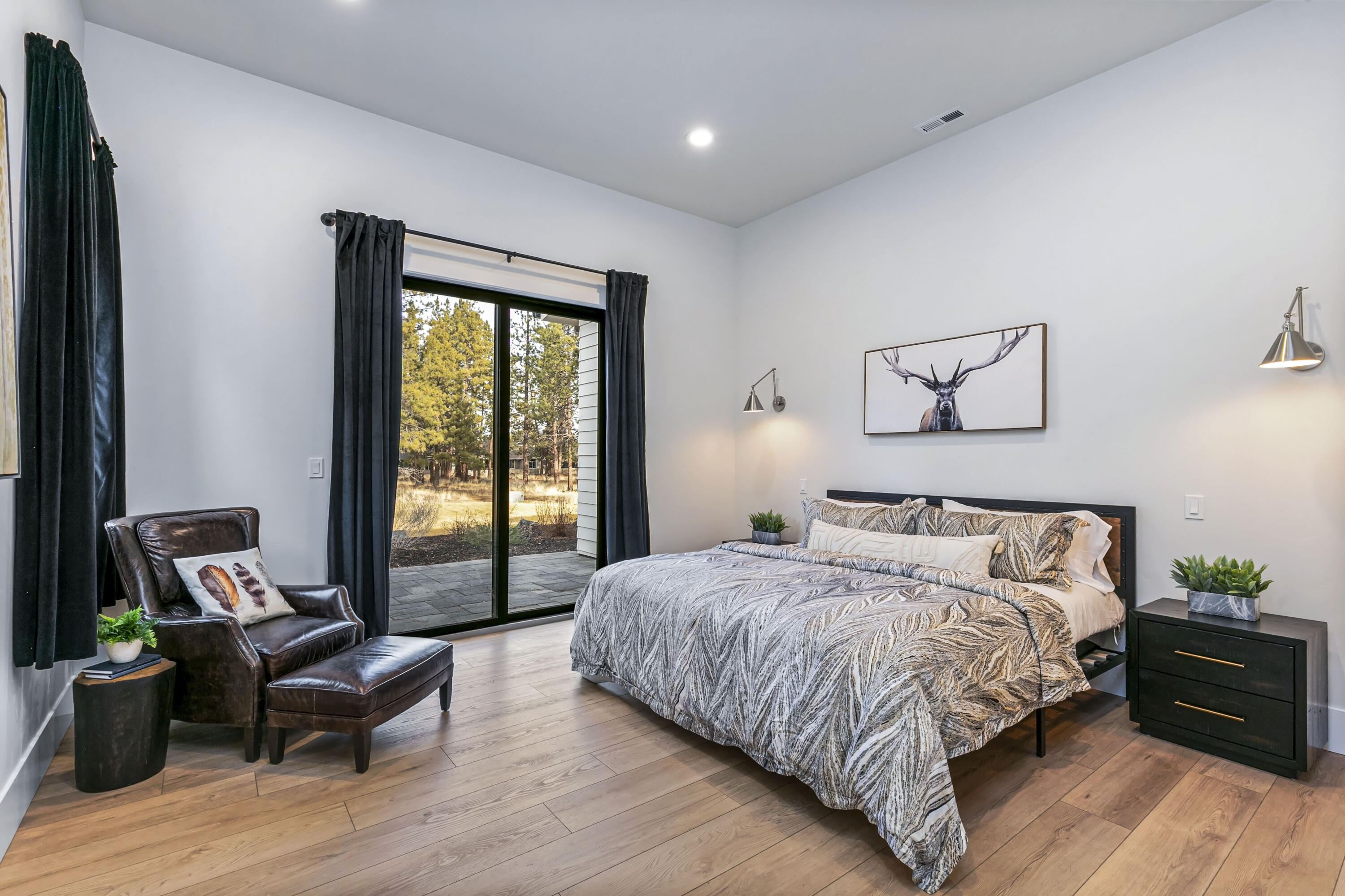 19550 Buck Canyon Road Bend, OR 97702 - Photo 9 of 28 a bedroom with a bed and wooden floor