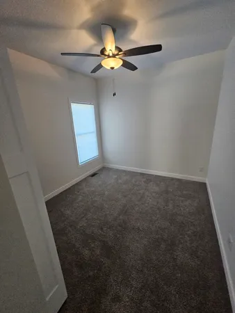 an empty room with a ceiling fan and fan