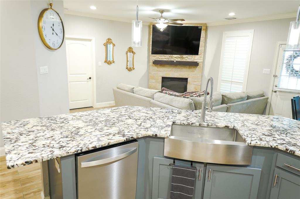 1012 Bowers Road Seagoville, TX 75159 - Photo 13 of 26 a kitchen with kitchen island granite countertop a sink and a stove with wooden floor