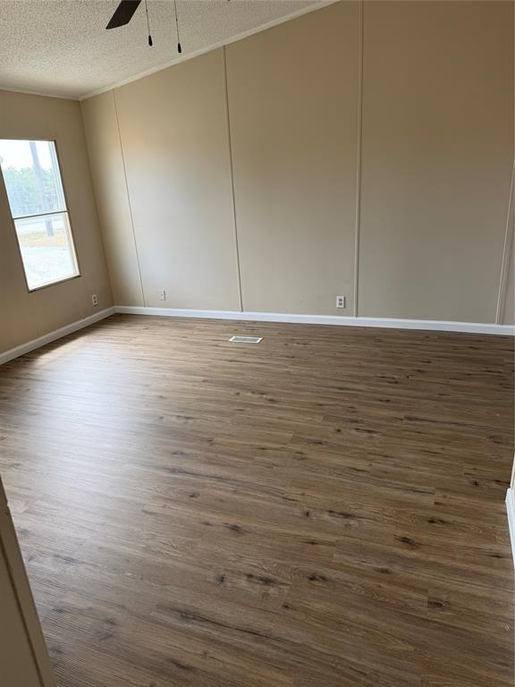 143 Summit Ridge Lane Springtown, TX 76082 - Photo 8 of 19 Vaulted ceiling with a ceiling fan, window with natural light, wood-finish flooring, and light-toned wall paneling