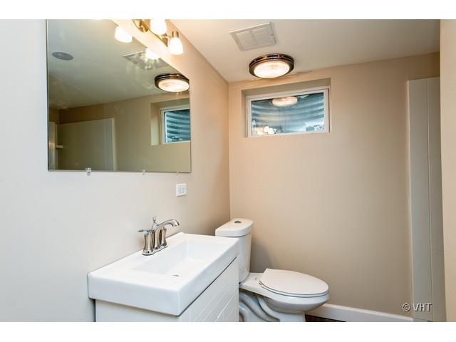 8500 Springfield Avenue Skokie, IL 60076 - Photo 14 of 15 a bathroom with a toilet a sink and mirror