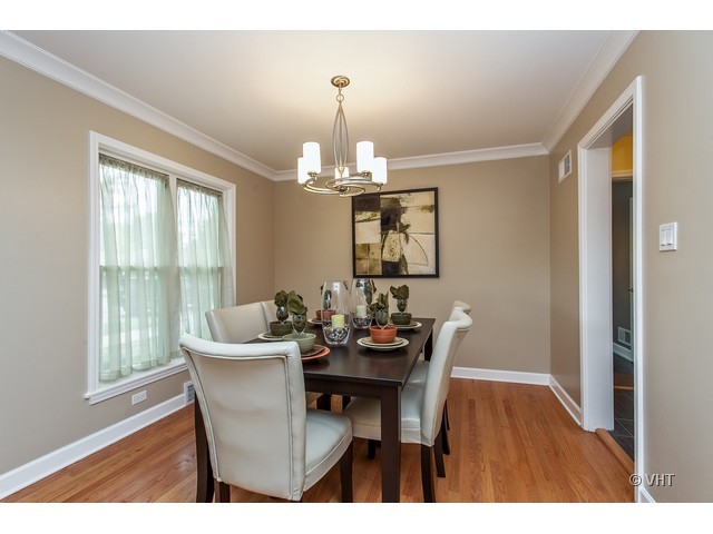 8500 Springfield Avenue Skokie, IL 60076 - Photo 7 of 15 a dining room with furniture a chandelier and wooden floor