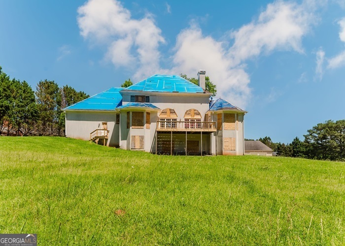a view of a house with a big yard and large trees
