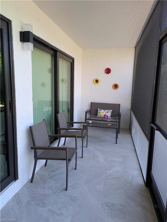 600 Neapolitan Way, Unit 147 Naples, FL 34103 - Photo 8 of 13 a living room with furniture and a window