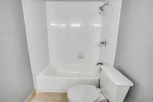 a bathroom with a toilet and a bath tub