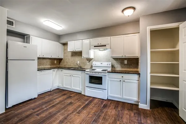 a kitchen with granite countertop white cabinets and white appliances