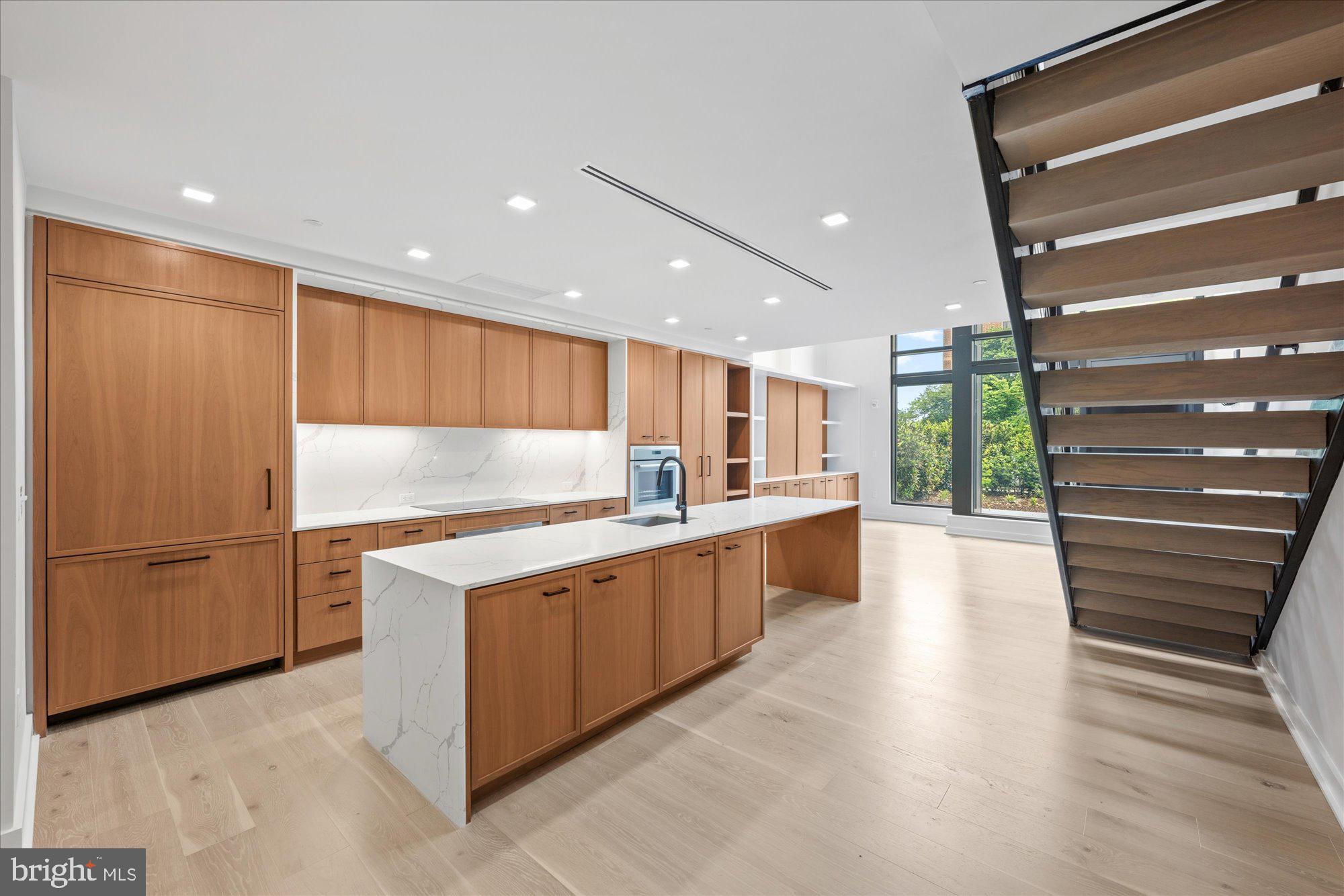 1336 8th Street Northwest, Unit TH5 Washington, DC 20001 - Photo 3 of 32 a kitchen with stainless steel appliances kitchen island granite countertop a refrigerator and a sink