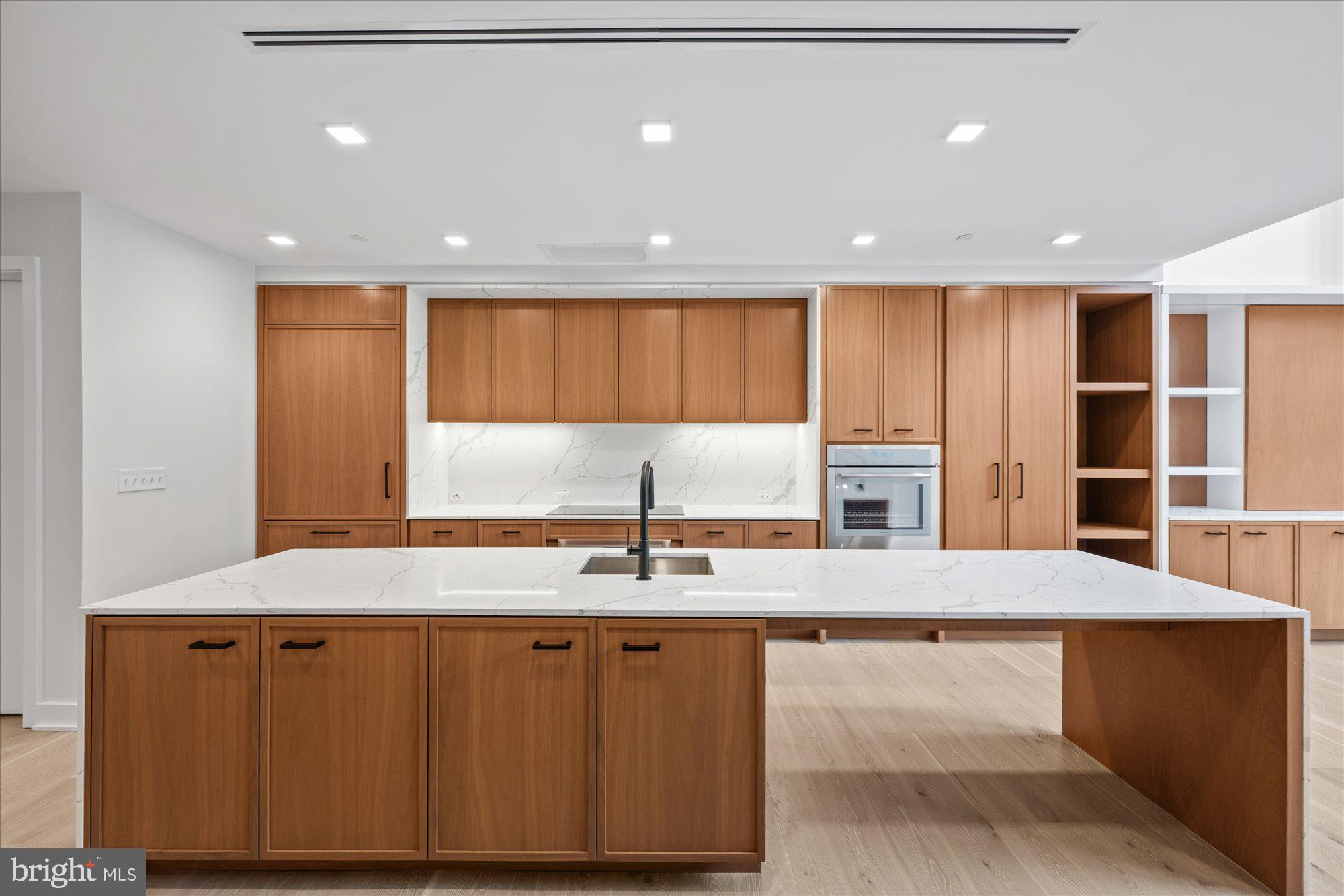 1336 8th Street Northwest, Unit TH5 Washington, DC 20001 - Photo 4 of 32 a kitchen with kitchen island granite countertop a stove a sink and a refrigerator with wooden floor