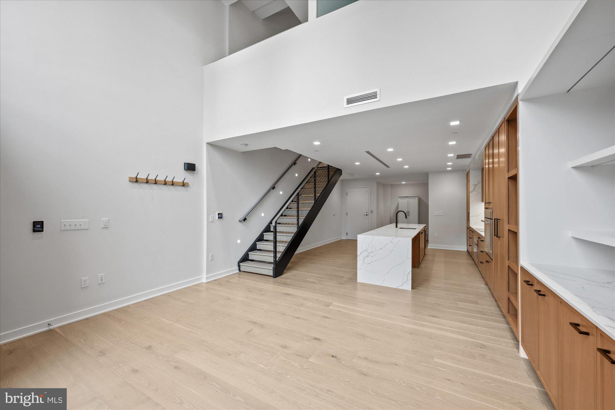 1336 8th Street Northwest, Unit TH5 Washington, DC 20001 - Photo 7 of 32 an empty room with wooden floor and stairs