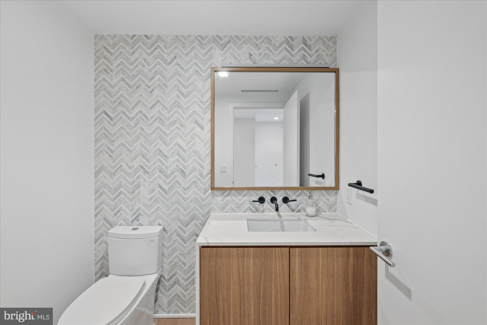 1336 8th Street Northwest, Unit TH5 Washington, DC 20001 - Photo 8 of 32 a bathroom with a granite countertop sink and a mirror with toilet