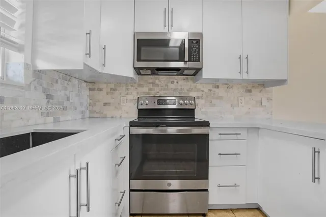 a kitchen with granite countertop a stove and a microwave