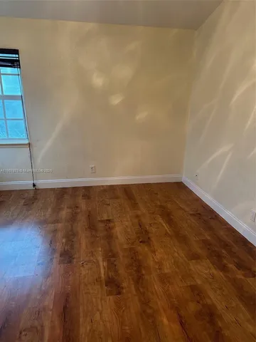 wooden floor in an empty room with a mirror