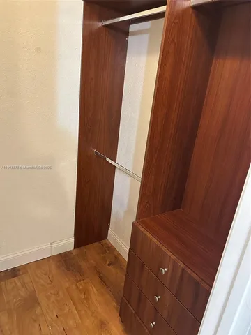 a view of a room with wooden floor and a window