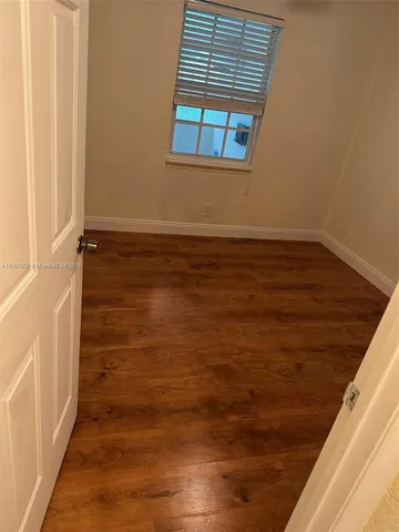 an empty room with wooden floor and closet