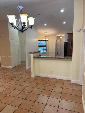 a kitchen with granite countertop a refrigerator and a stove top oven
