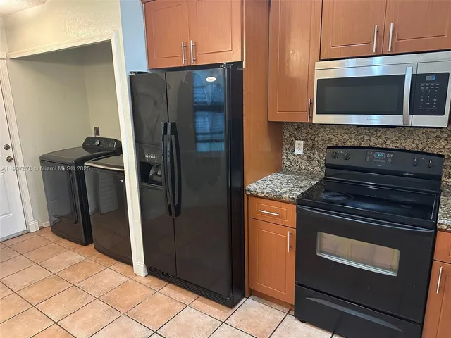 a kitchen with stainless steel appliances granite countertop a refrigerator and a stove