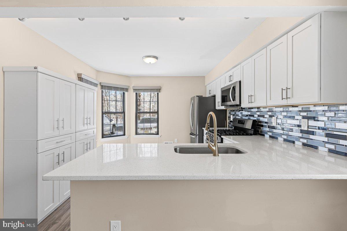 9 Devon Court Robbinsville, NJ 08691 - Photo 6 of 22 a kitchen with kitchen island a sink appliances and cabinets