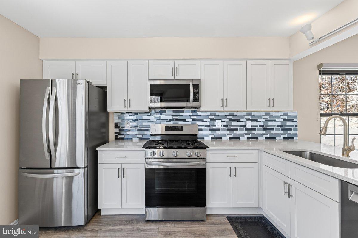 9 Devon Court Robbinsville, NJ 08691 - Photo 7 of 22 a kitchen with white cabinets and stainless steel appliances
