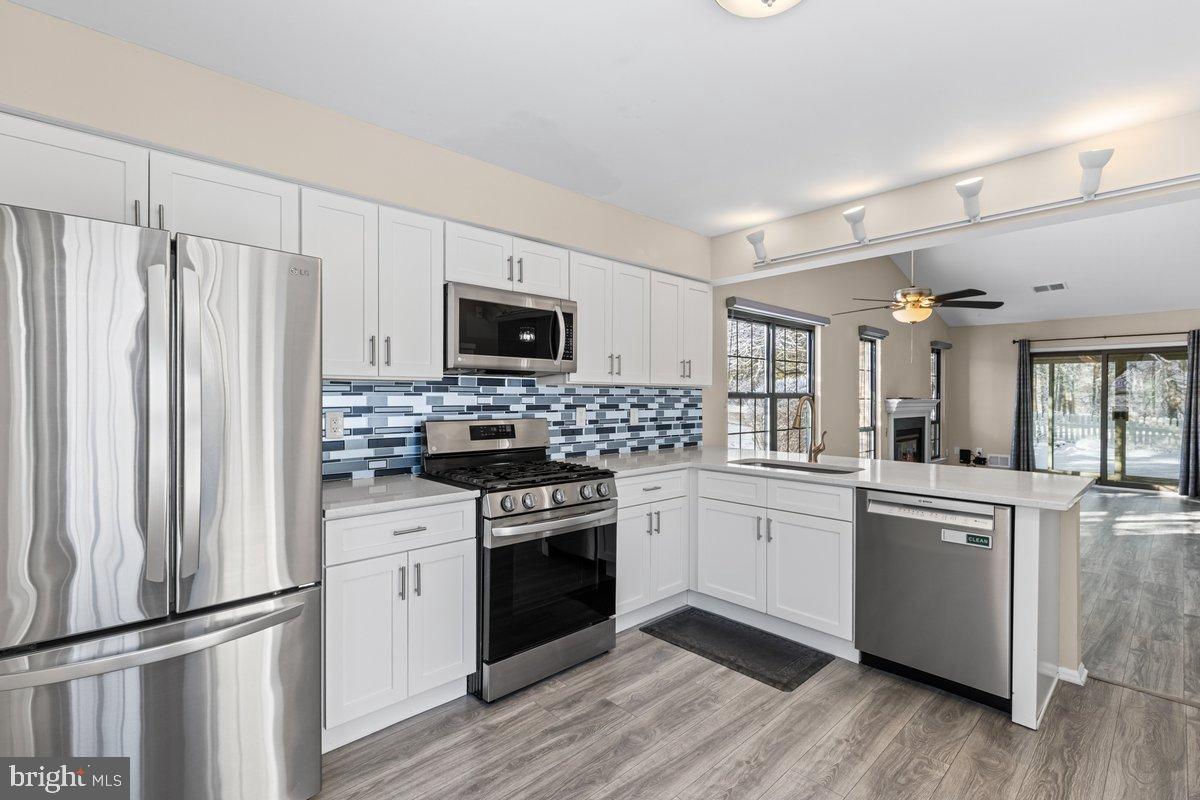 9 Devon Court Robbinsville, NJ 08691 - Photo 8 of 22 a kitchen with white cabinets appliances and wooden floor