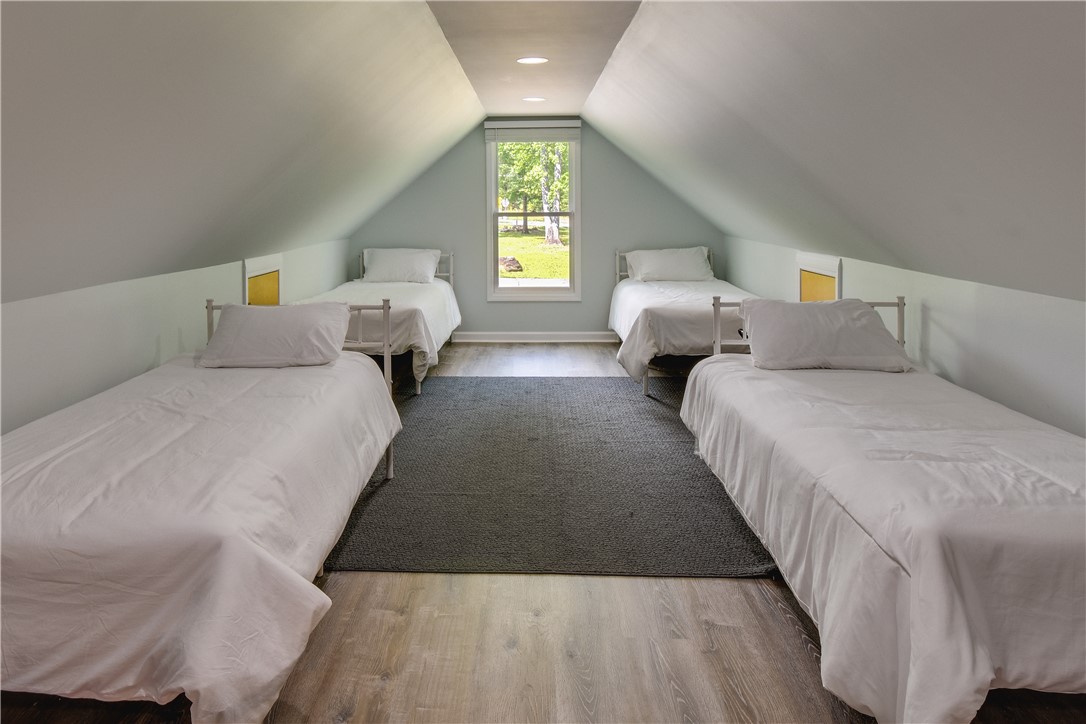 206 Petty Road Seneca, SC 29672 - Photo 33 of 48 An attic bedroom with a charming window view, showcasing sloped ceilings and ample space.