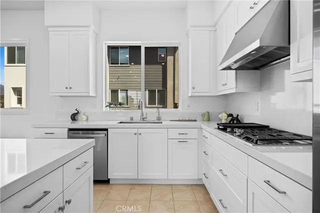 a kitchen with cabinets appliances a sink and a window