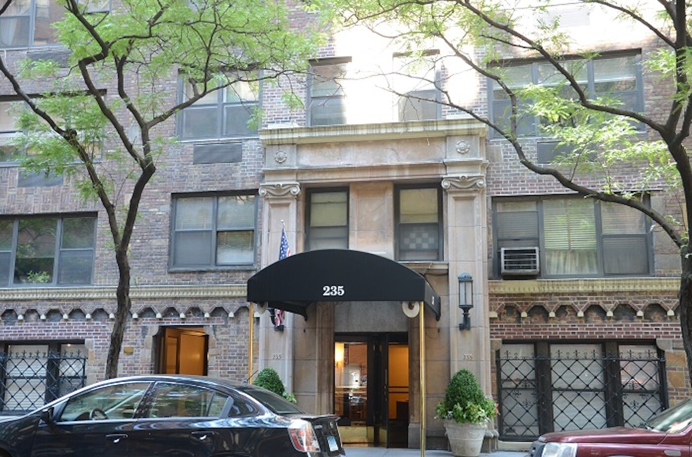 235 East 73rd Street, Unit 6F Manhattan, NY 10021 - Photo 7 of 9 a front view of a building with large trees