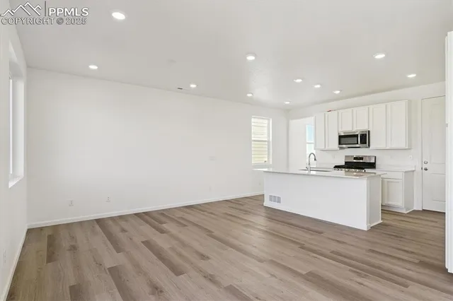 a view of kitchen with wooden floor and electronic appliances