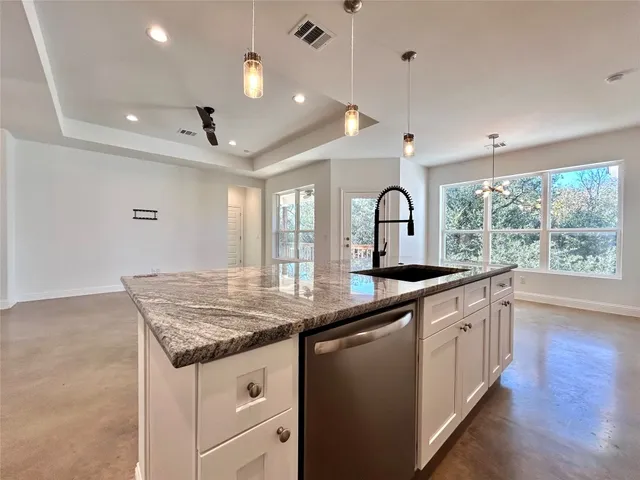 a kitchen with stainless steel appliances a refrigerator sink and white cabinets