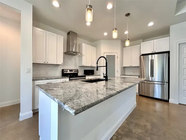 a view of an empty room and a kitchen
