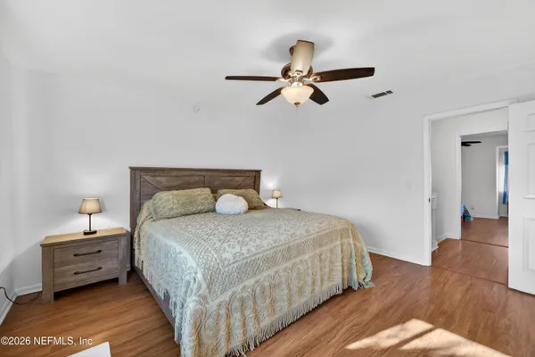 a bedroom with a bed and wooden floor