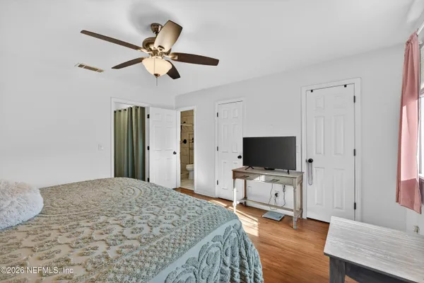 a bedroom with a bed and a flat screen tv