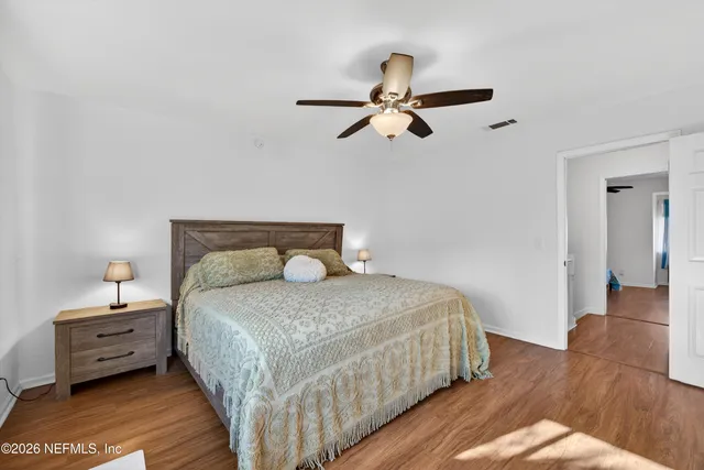a bedroom with a bed and wooden floor