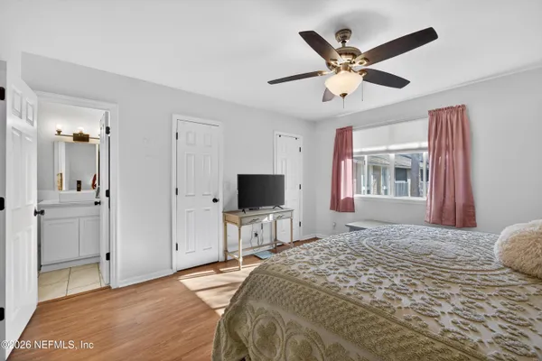 a bedroom with a bed and a large mirror on the dresser