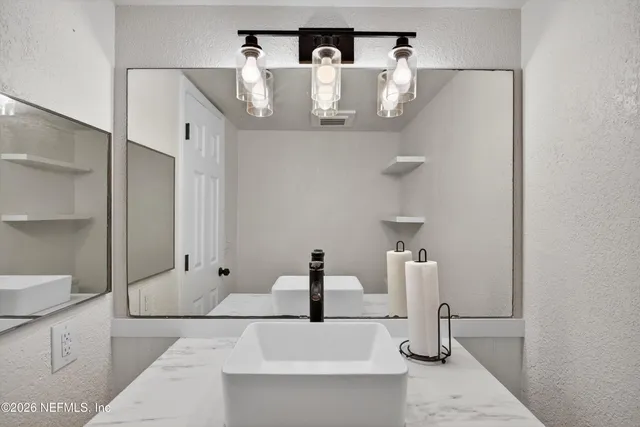 a bathroom with a sink and mirror