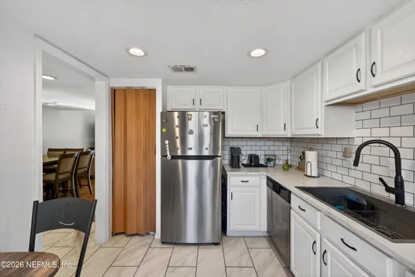 a kitchen with a refrigerator a sink a stove and cabinets