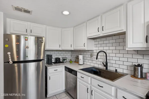 a kitchen with stainless steel appliances a refrigerator sink and cabinets